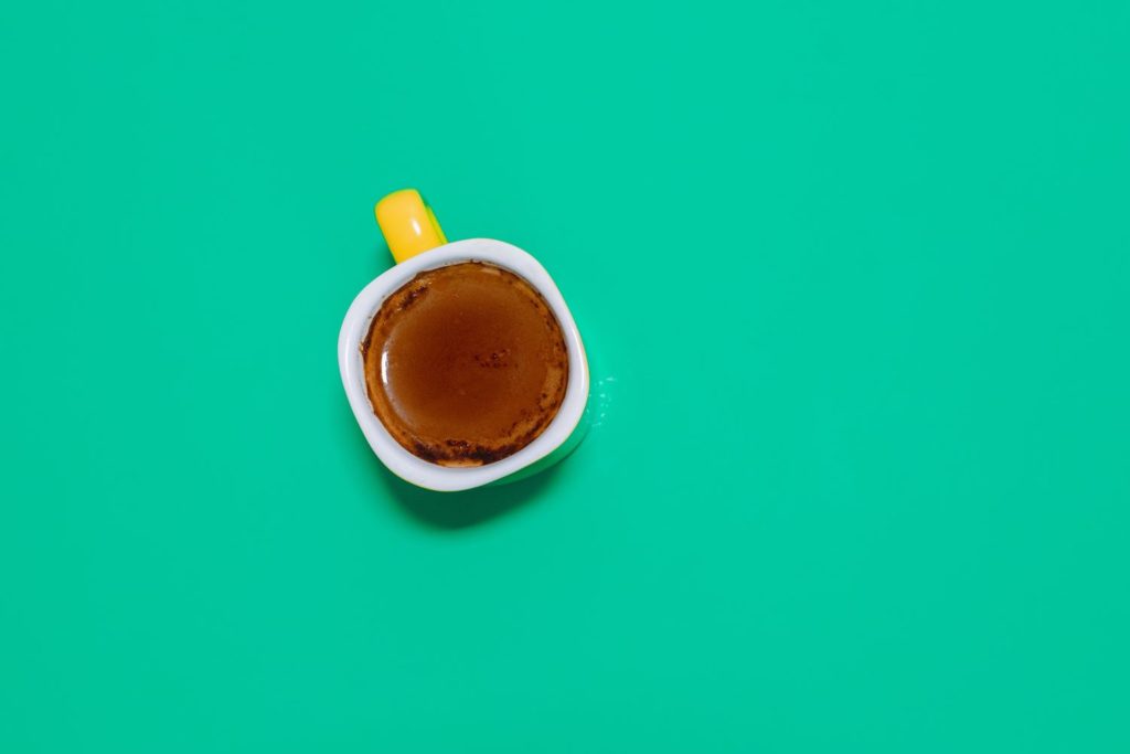 Cup of Coffee with Collagen on Teal Background